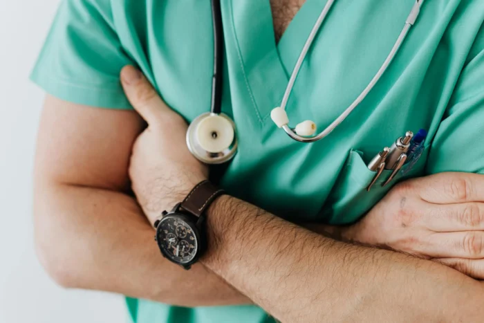 A Levels for Medicine Degree, A Doctor in scrubs with his arms folded, StudySmarter Magazine